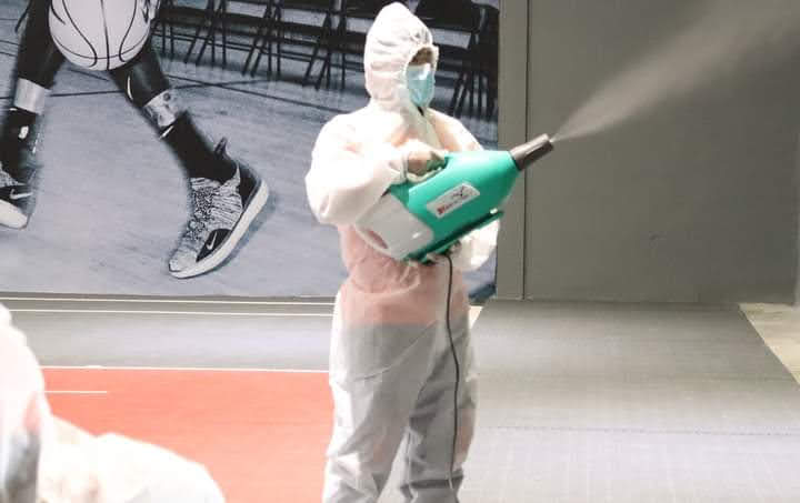 Staff disinfecting office surfaces and high-touch areas with professional-grade equipment