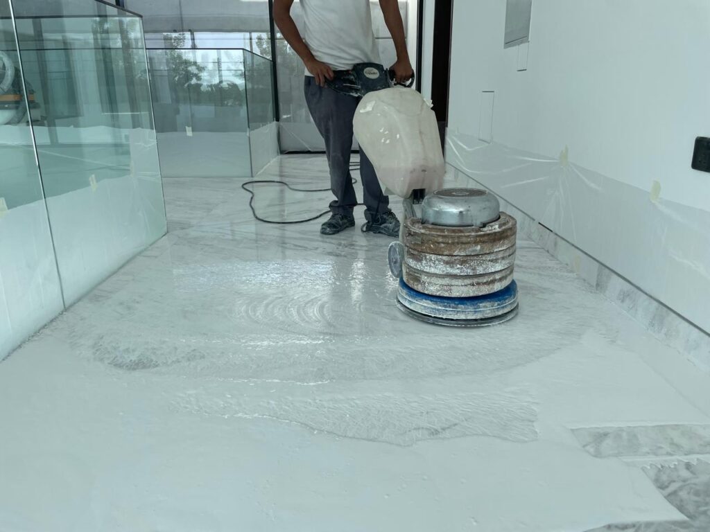 Technician grinding the floor with a commercial machine for Marble Polishing and Restoration Services.
