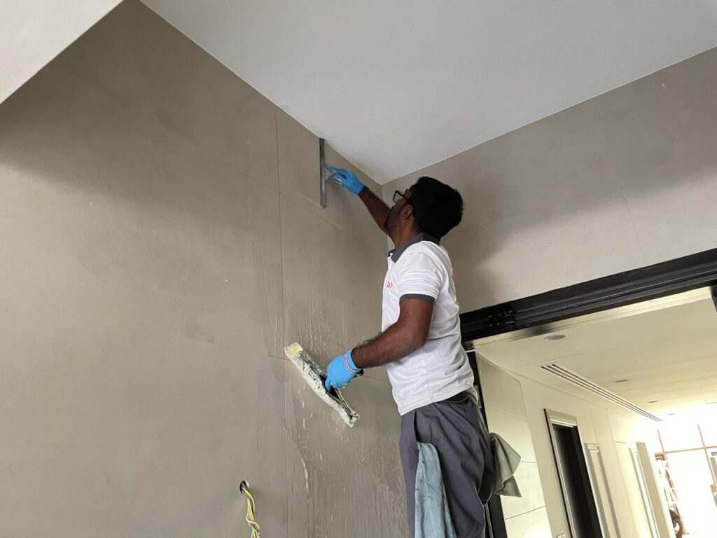 one cleaning staff villa entrance wall deep cleaning with applicator & weeper. our cleaning services in Arabian ranches